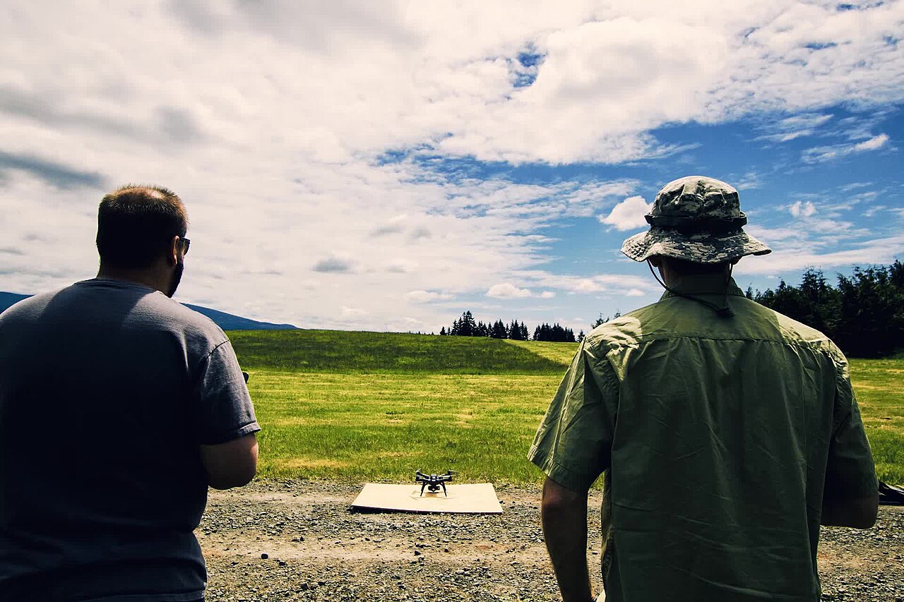 A quadcopter drone in flight against the sky.