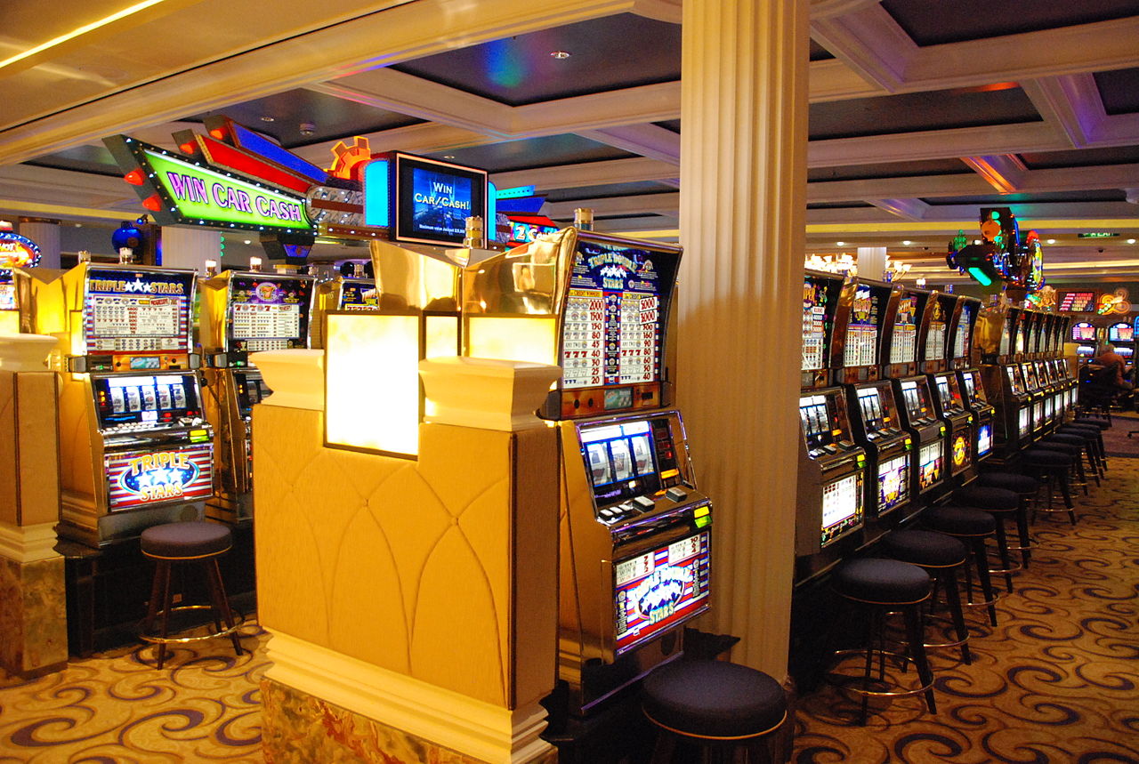 A row of slot machines glowing in a casino.